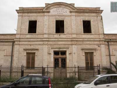 ...mentre l'ingresso principale posto sotto di esso risulta sbarrato da una ringhiera arruginita